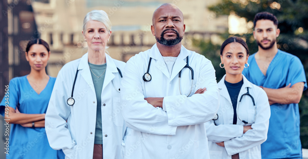 Were serious about our work. Shot of a group of doctors standing with their arms crossed in the city
