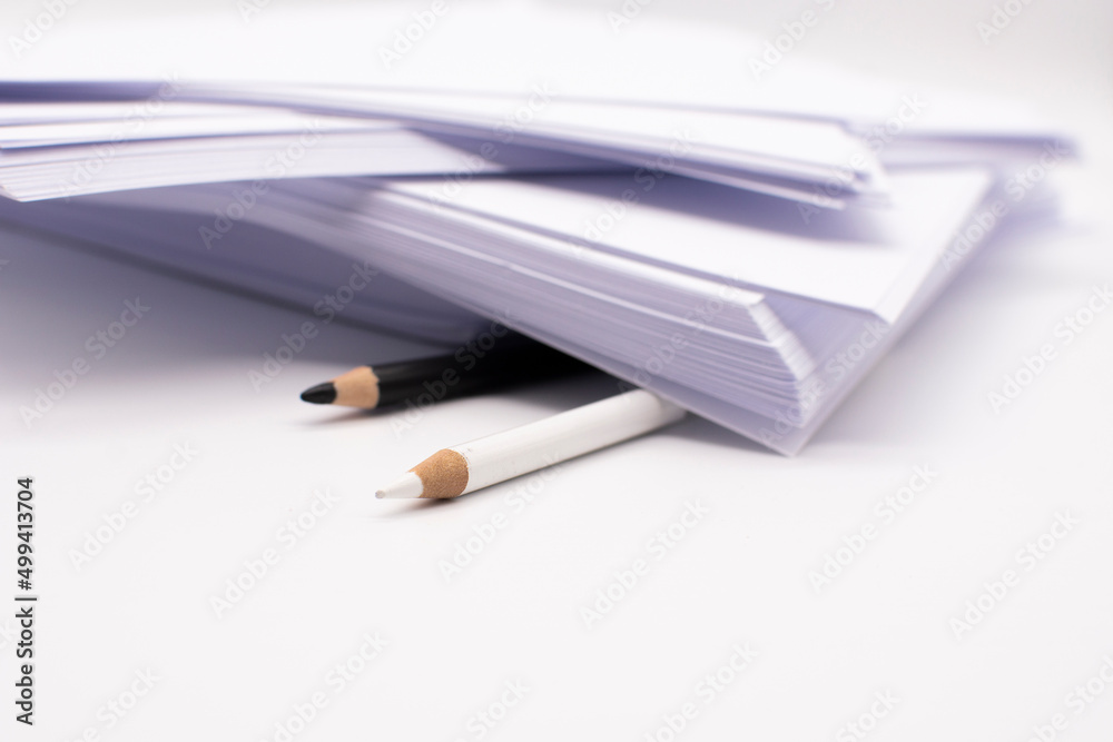 一沓白色办公纸，桌面上有黑白铅笔。商业概念