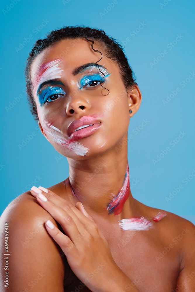 Let me be your colourful canvas. Studio portrait of a beautiful young woman covered in face paint po