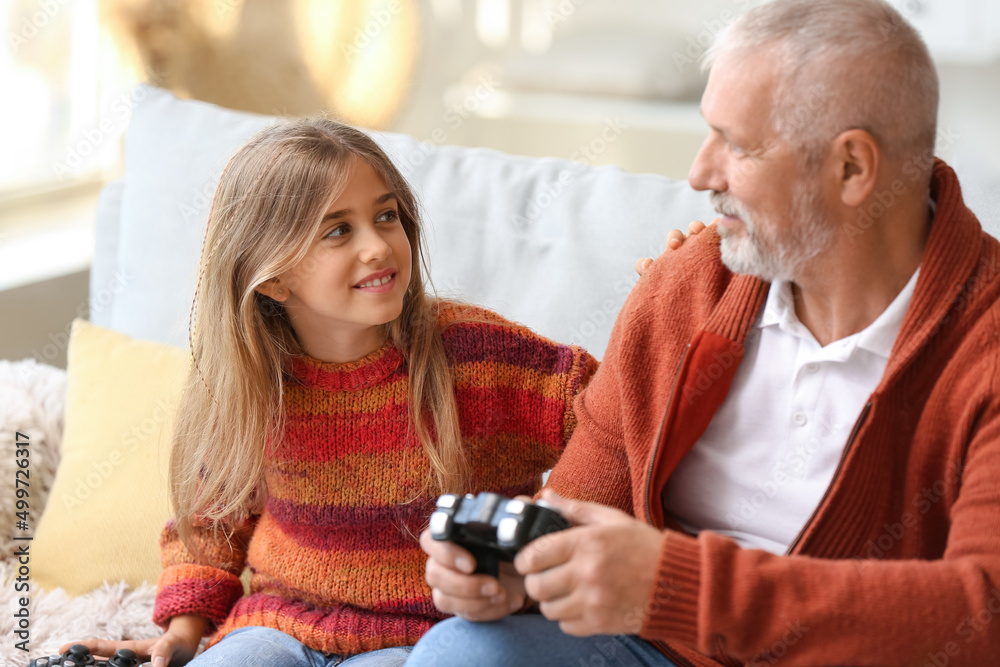 小女孩和爷爷在家玩电子游戏