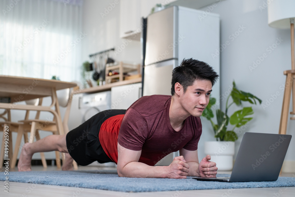 亚洲英俊活跃的年轻人在客厅地板上锻炼