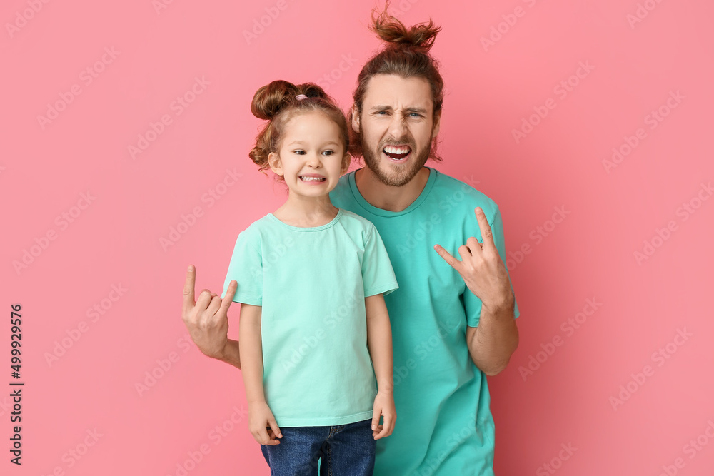 粉色背景下的滑稽男子和她的小女儿。愚人节庆祝活动