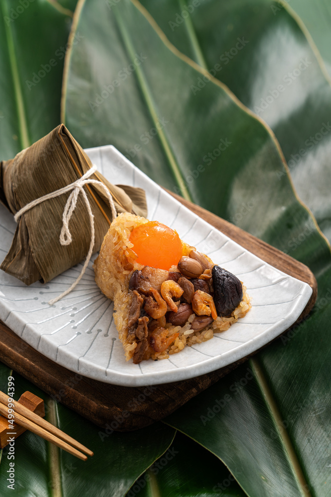 Zongzi. Rice dumpling for Dragon Boat Festival on green leaf background with ingredient.