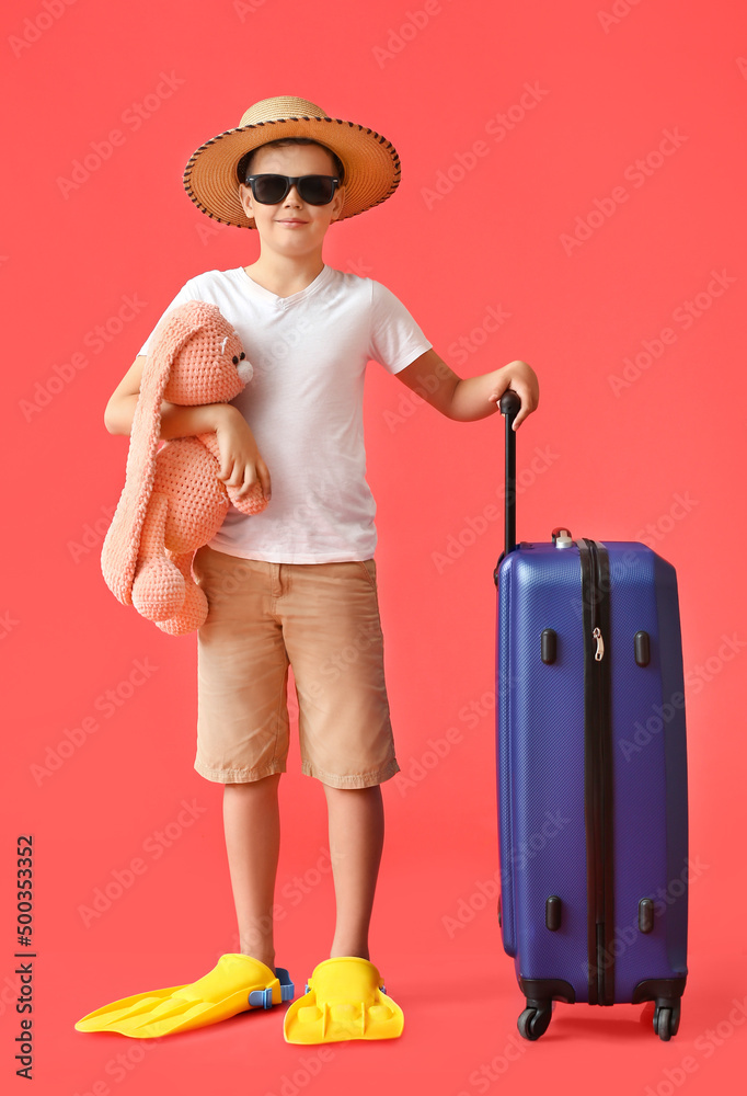 可爱的小男孩，带着行李箱、兔子玩具和彩色背景的球拍