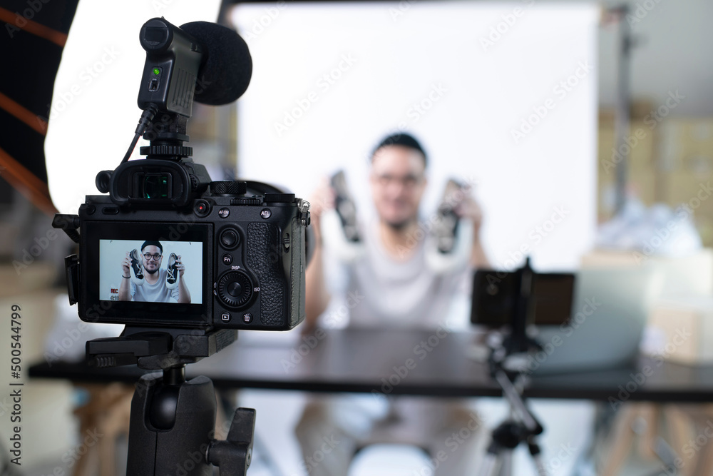 年轻有魅力的亚洲男性博主或vlogger看着相机评论产品。现代商务女性