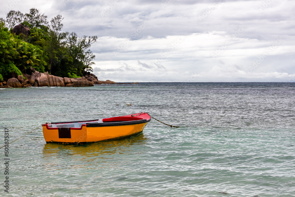 停泊在塞舌尔马埃岛Baie Lazare公共海滩的红色和橙色旧木制渔船