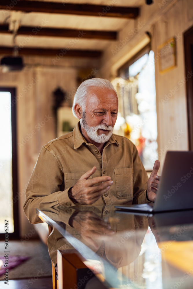 一名老年男子通过笔记本电脑与某人通话，视频通话。
