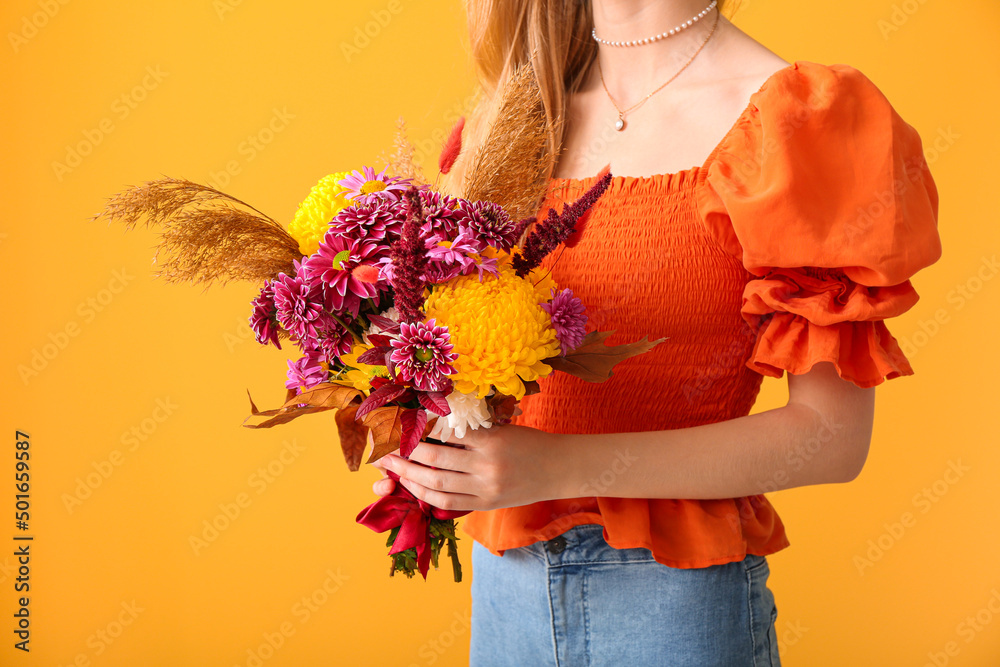 黄色背景下带着美丽秋天花束的女人，特写