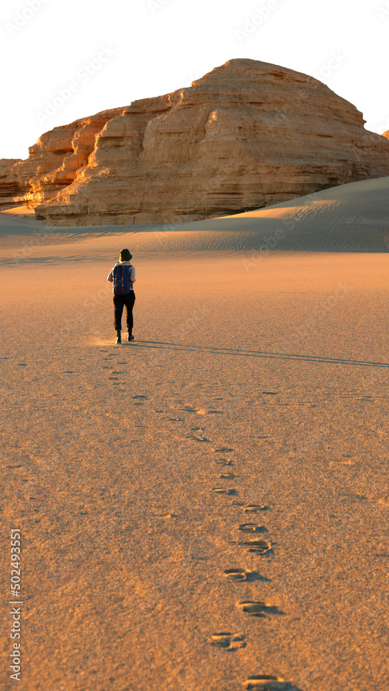 行走在沙漠中的亚洲女性旅游背包客