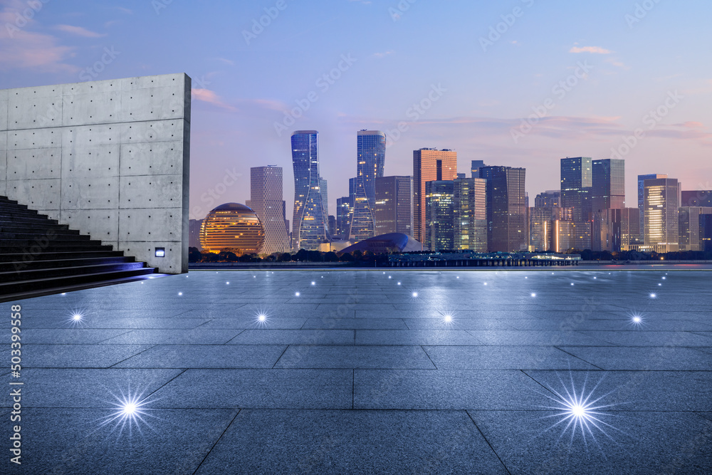 日出时，中国杭州，空旷的广场层和城市天际线，现代商业建筑。