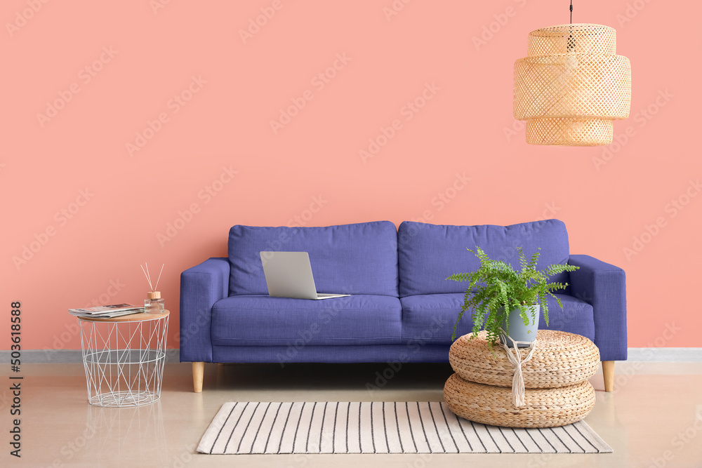 粉色墙壁附近舒适的沙发和时尚的吊灯