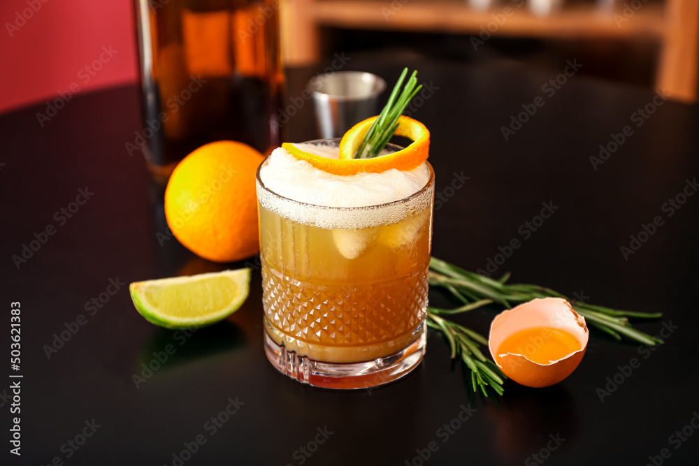 一杯美味的威士忌酸鸡尾酒，用迷迭香枝、橘子皮和配料装饰