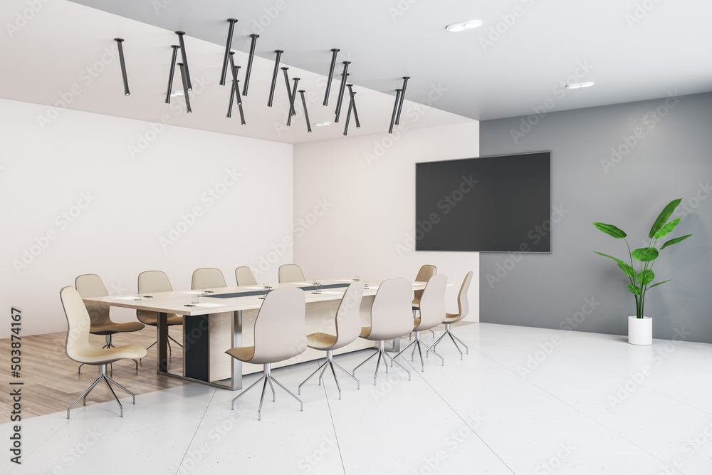 干净的设计师会议室内部，配有家具、空的实体演示框架和日光。