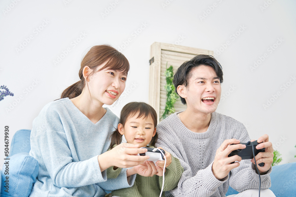 両親と娘　テレビゲームで遊ぶ　リビング