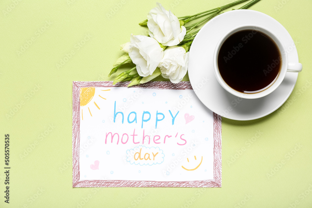 卡片上写着母亲节快乐，绿色背景上有鲜花和一杯咖啡