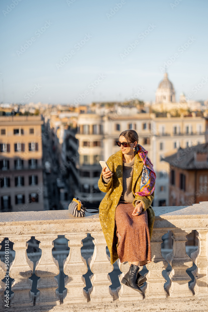 Woman enjoying beautiful morning cityscape of Rome, sitting on the top of famous Spanish steps. Old 