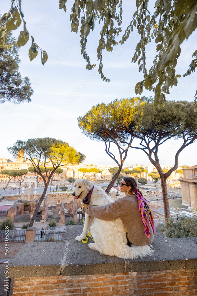一个女人和一只狗坐在一起，从罗马市中心欣赏美景。考克