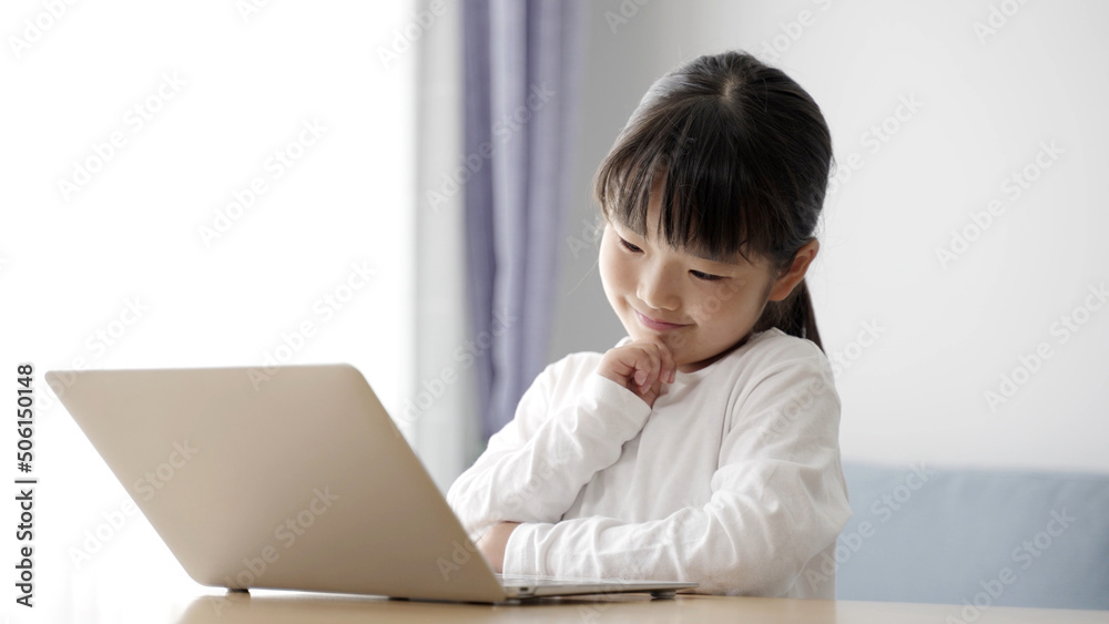 パソコンを使いながら考え事をする女の子