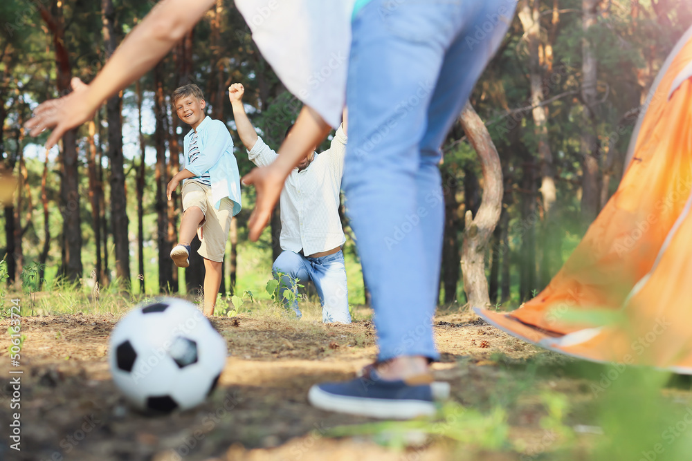 小男孩和他的父亲和祖父在森林里踢足球