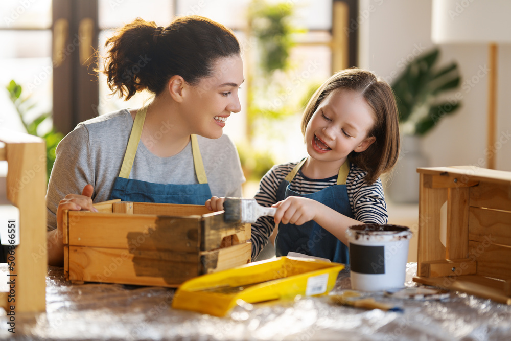 mother and daughter painting a wooden box