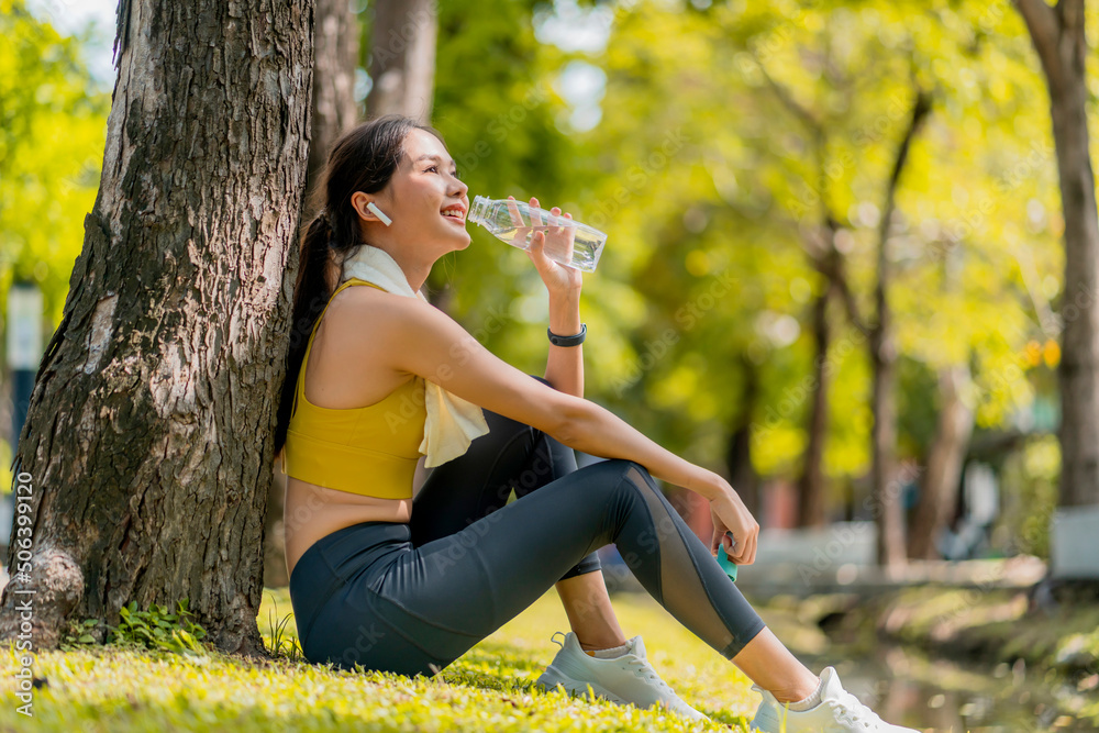 young Woman drinking water from bottle. asian female drinking water after exercises or sport. Beauti