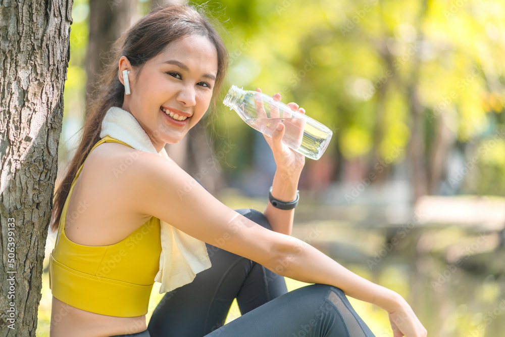 young Woman drinking water from bottle. asian female drinking water after exercises or sport. Beauti