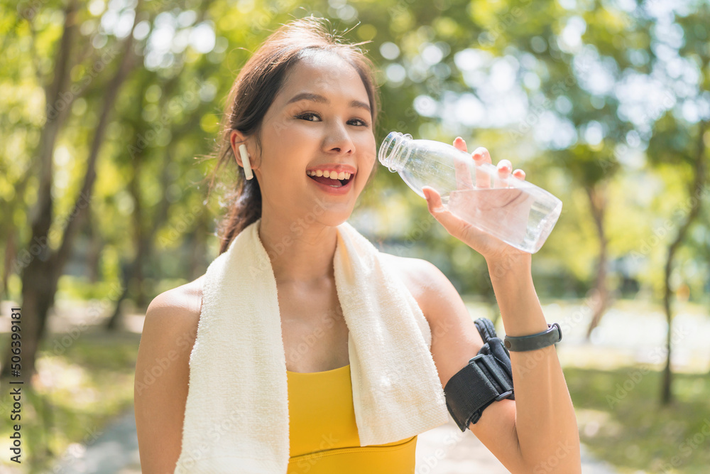 年轻女性用奶瓶喝水。亚洲女性锻炼或运动后喝水。Beauti