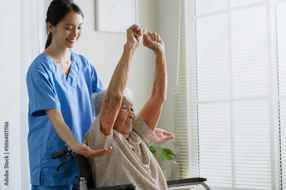 年轻的亚洲女性护士，护理人员帮助一名亚洲老年女性进行物理治疗和锻炼