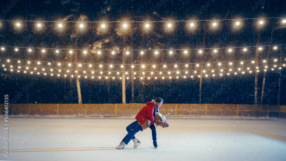 冬季仙境：滑冰情侣在溜冰场度过一个神奇的夜晚。美丽的雪法