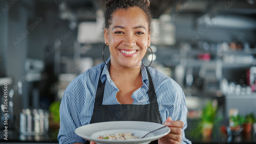 餐厅厨房：黑人女厨师的画像准备菜肴，品尝食物，享受美食。专业