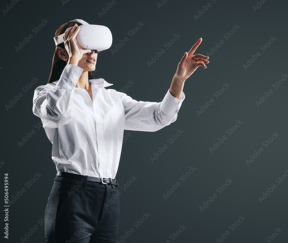 戴着VR眼镜在虚拟现实环境中工作的年轻女商人，用手指按压v