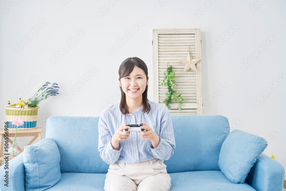 リビングで笑顔でテレビゲームをする女性
