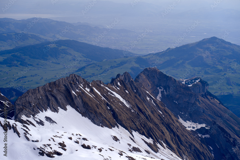 Panoramic landscape with rocks, hills and Rhine Valley in the background seen from Säntis peak at Al