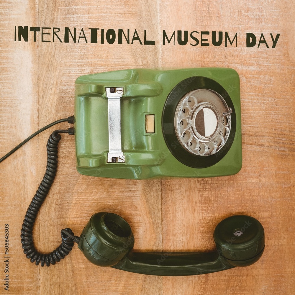 绿色古董旋转电话与木桌上的国际博物馆日文字的组合