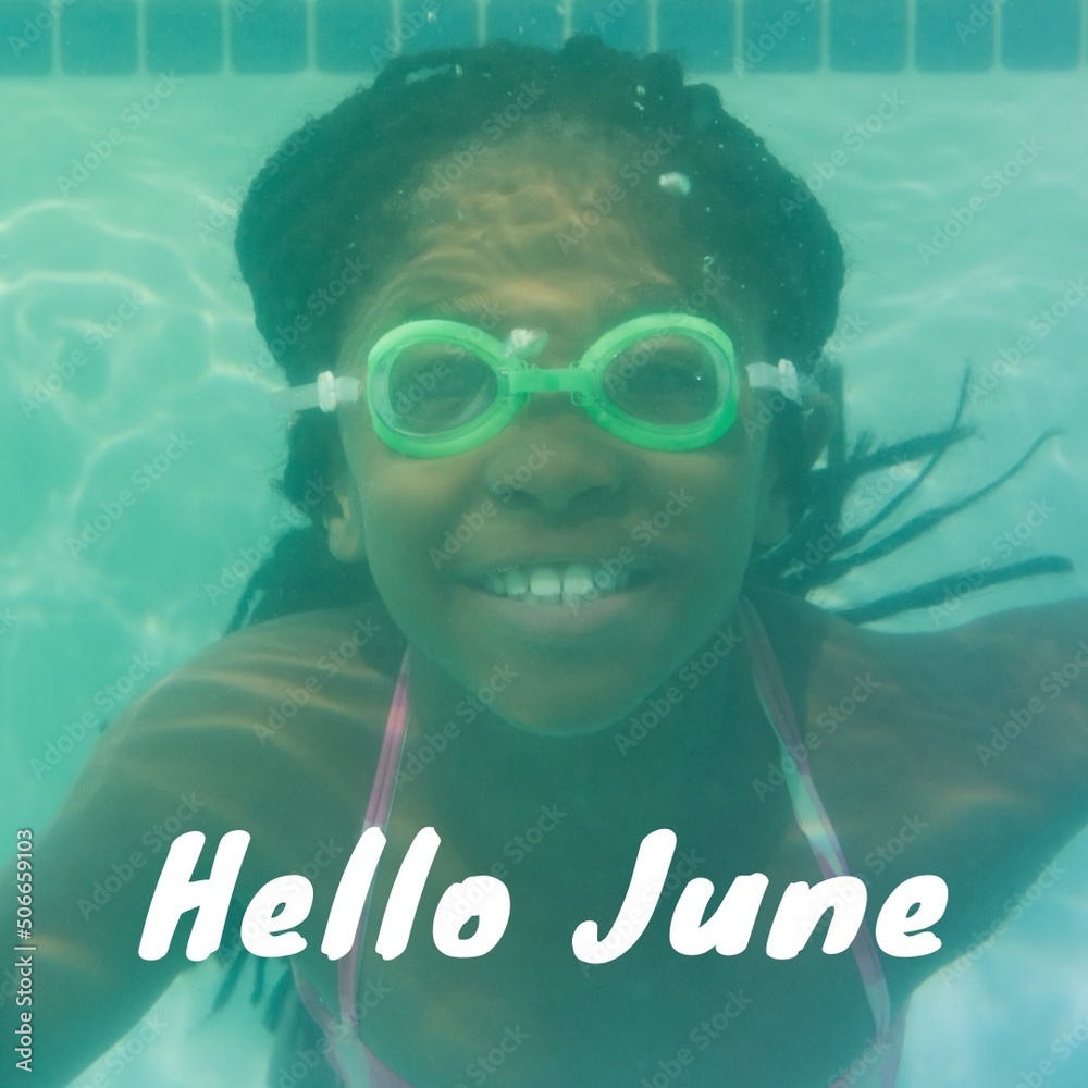 Potrait of smiling african ameican girl swimming underwater in pool with hello june text