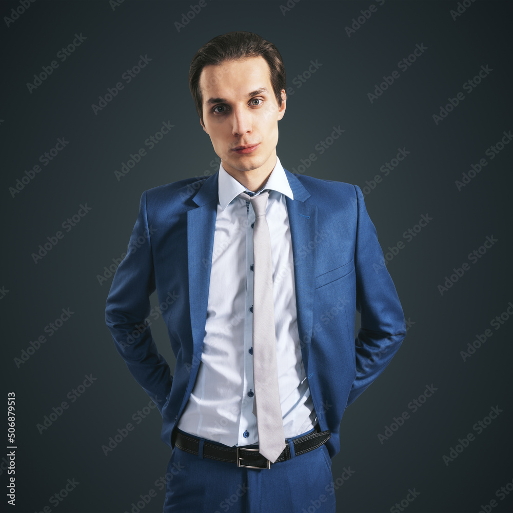 年轻成功的商人，身穿蓝色西装，黑底灰色领带，特写