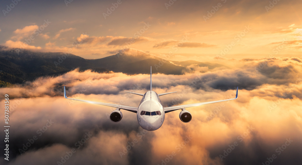 夏天日落时，飞机在云层上方飞行。风景与客机，山