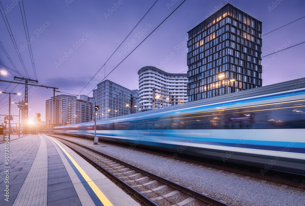 日落时分，高速列车在火车站上行驶。蓝色的现代城际旅客