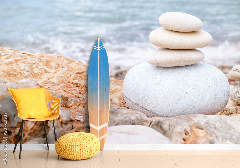 冲浪板、扶手椅和靠近墙壁的垫子，沙滩上有鹅卵石的印花