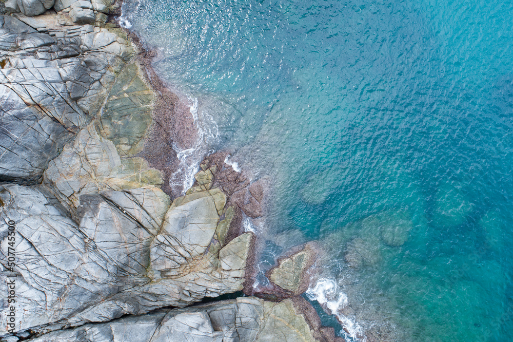 鸟瞰图自上而下的海岸波浪拍打着海岸阳光明媚的绿松石海面