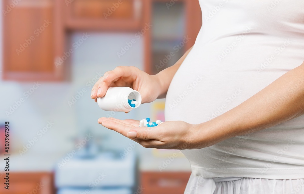 孕妇喝含有维生素的药物。怀孕、健康、药物、护理和人。