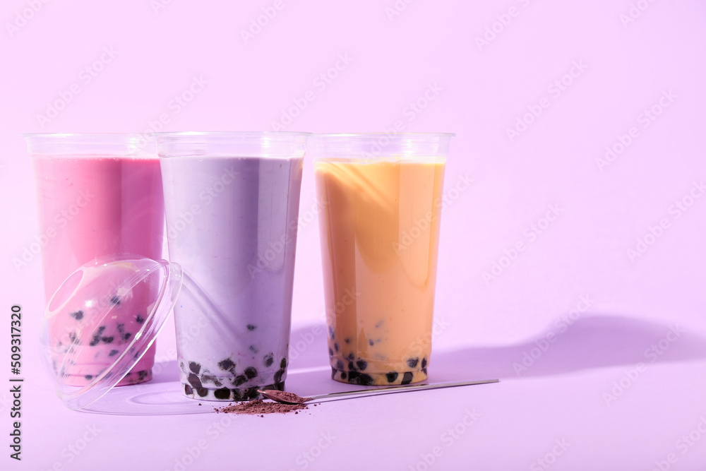 紫色背景的不同美味气泡茶塑料杯