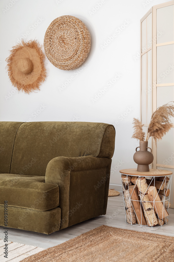 带绿色沙发、折叠屏幕和装饰的浅色客厅内部