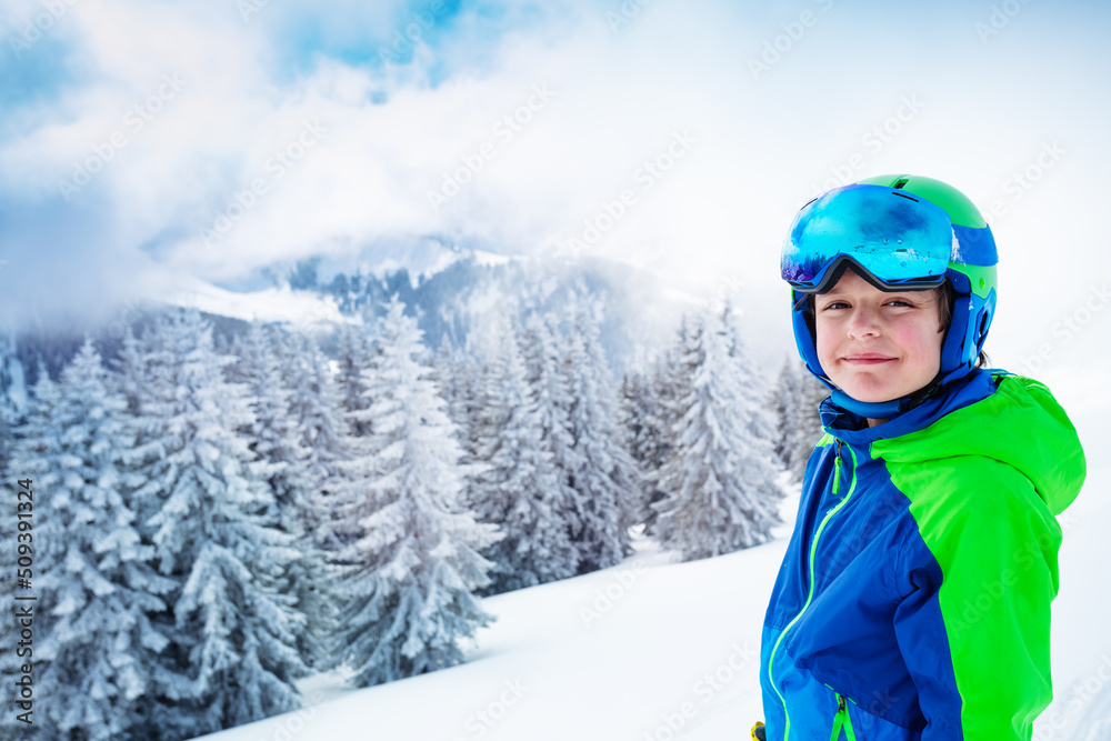 雪后森林上穿着滑雪服的男孩微笑的画像