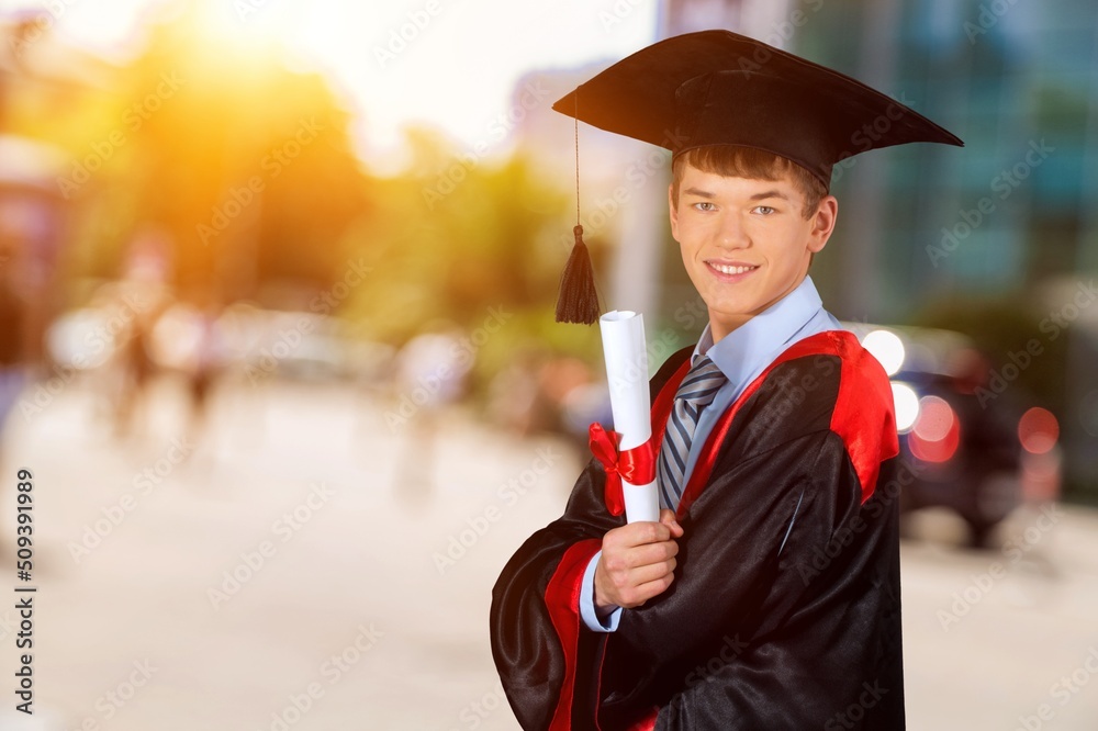 男人毕业戴帽子，站在城市景观上，教育理念