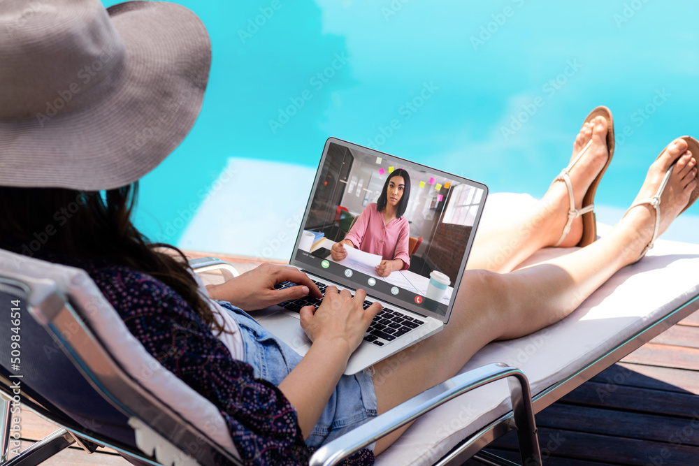 高加索女商人与坐在泳池边的高加索女同事视频会议