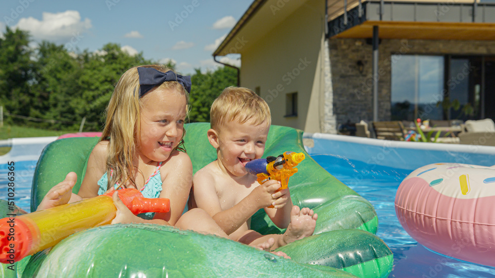 特写两个快乐的孩子在后院的游泳池里微笑着玩得很开心