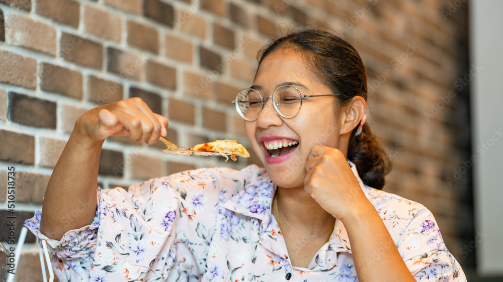 亚洲女人拿着新鲜的自制意大利披萨玛格丽塔和微笑，一片热披萨大切块