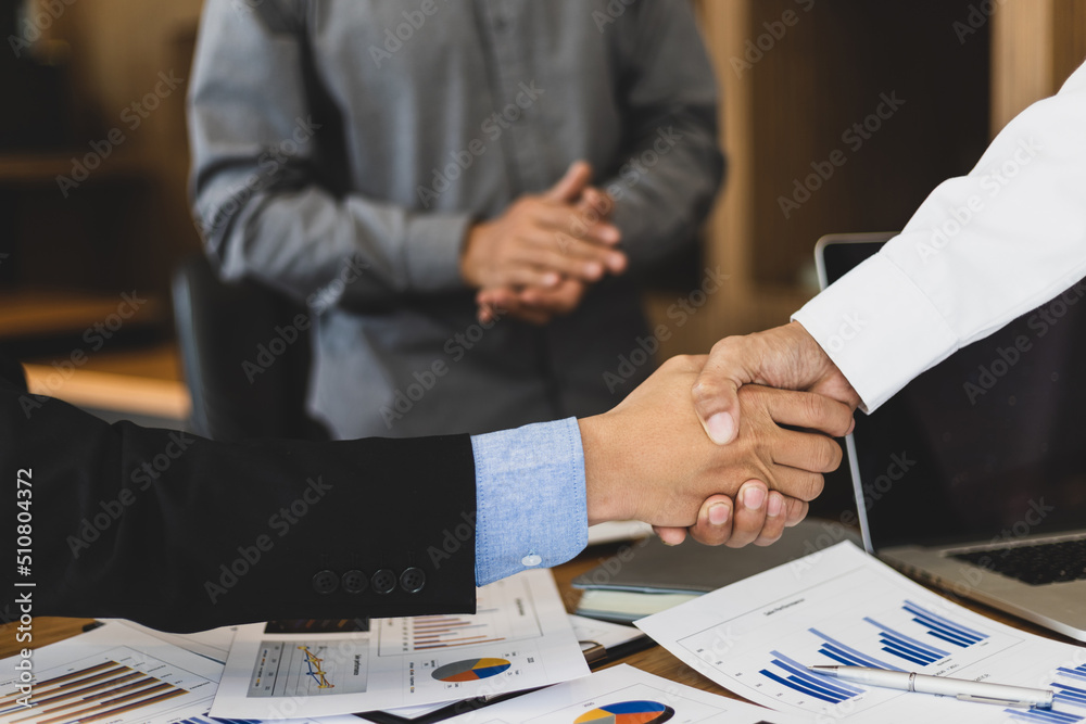 握手。商业人士在商业规划分析会议后与商业伙伴握手