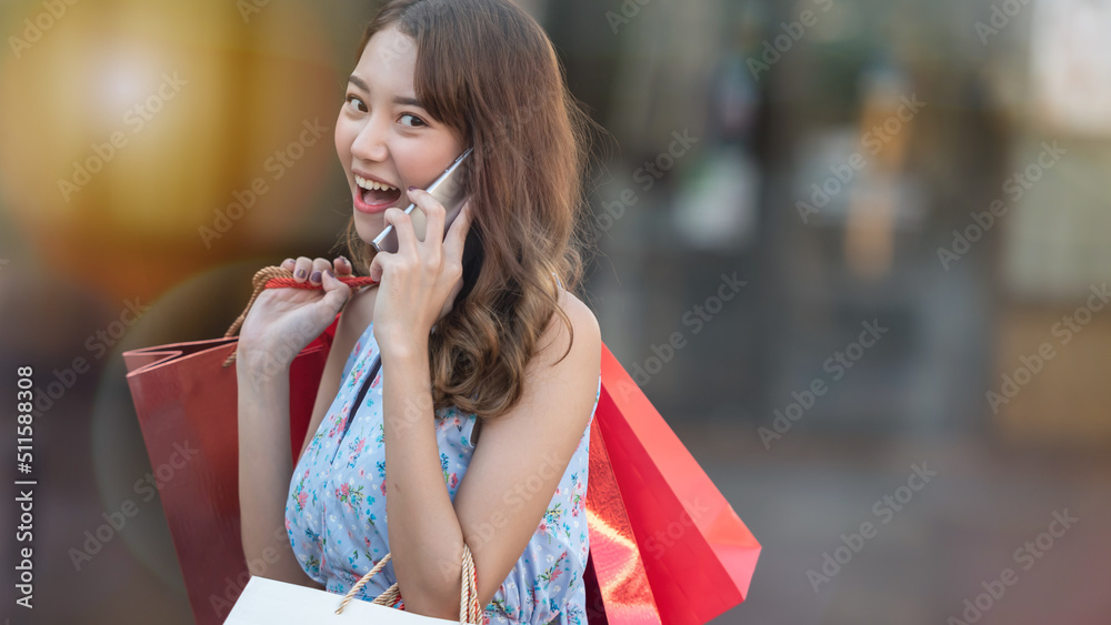 年轻女子购物时使用手机。